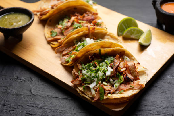 istock Pork tacos called al pastor with pineapple on dark background. Mexican tacos 1318944401