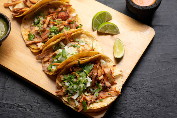 istock Pork tacos called al pastor with pineapple on dark background. Mexican tacos 1318944429