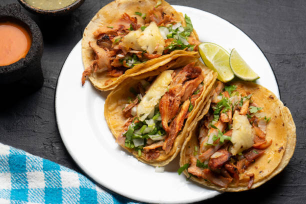 istock Pork tacos called al pastor with pineapple on dark background. Mexican tacos 1318946355
