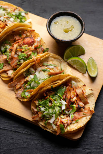istock Pork tacos called al pastor with pineapple on dark background. Mexican tacos 1318946368