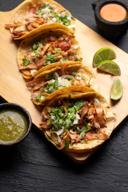 istock Pork tacos called al pastor with pineapple on dark background. Mexican tacos 1318946434