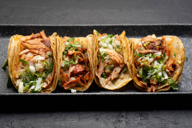 istock Pork tacos called al pastor with pineapple on dark background. Mexican tacos 1318946471