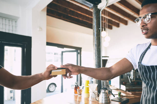 istock Shot of a man using a credit card to make a payment in a cafe 1318949896