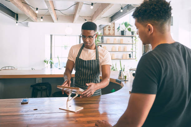 istock Shot of a young man using a digital tablet while buying coffee in a cafe 1318950027