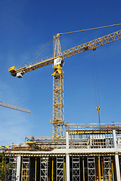 Cranes and building construction Building under construction and crane construction skyscraper machine industry stock pictures, royalty-free photos & images