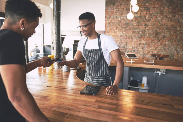 istock Shot of a man using a smartphone to make a payment in a cafe 1318951972