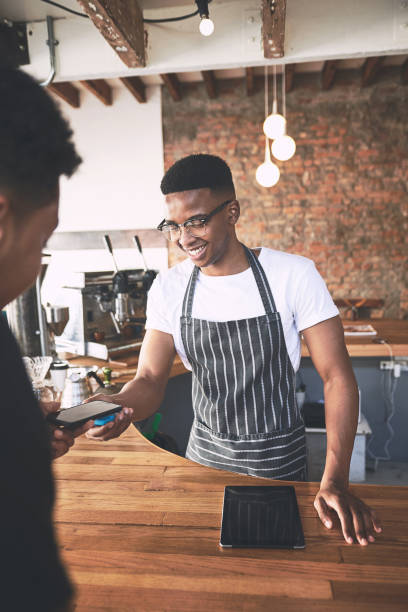 istock Shot of a man using a smartphone to make a payment in a cafe 1318951975