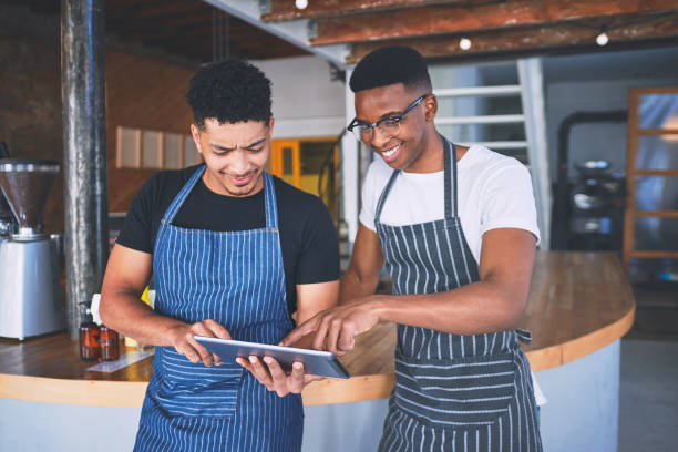istock Shot of two young men using a digital tablet while working in a cafe 1318953497