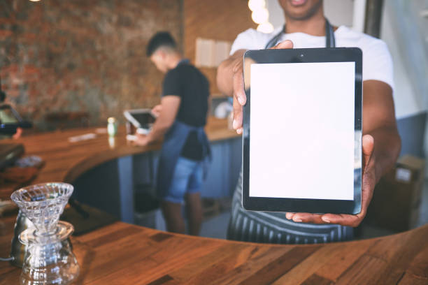 istock Shot of a man showing a digital tablet with a blank screen while working in a cafe 1318953577
