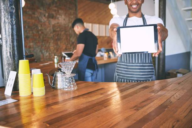 istock Shot of a man showing a digital tablet with a blank screen while working in a cafe 1318953578