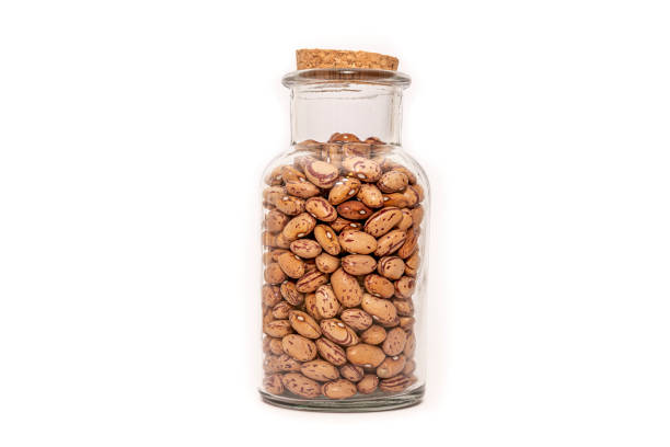 An isolated bottle of dried Borlotti Beans on a white background, food preservation. Dehydrated Beans, nutritious healthy ingredient.