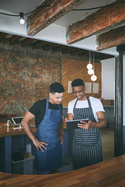 istock Shot of two young men using a digital tablet while working in a cafe 1318954389