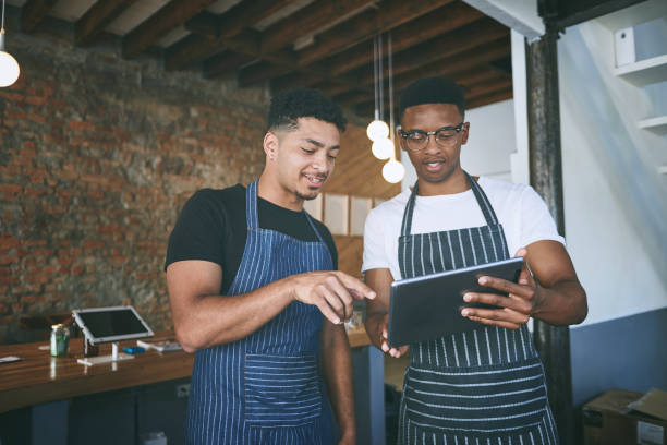 istock Shot of two young men using a digital tablet while working in a cafe 1318954391