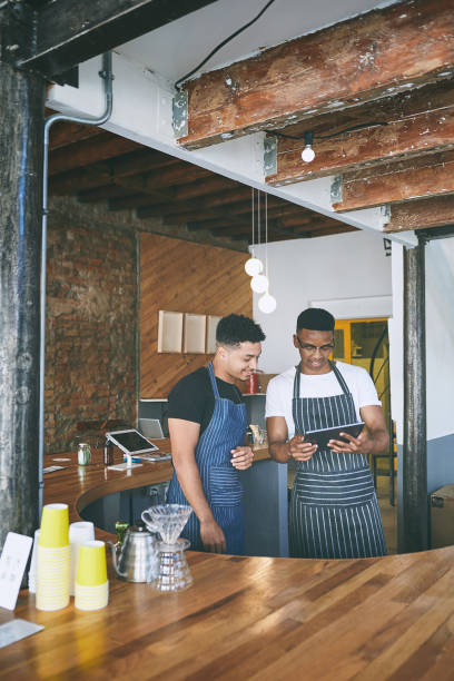 istock Shot of two young men using a digital tablet while working in a cafe 1318954399
