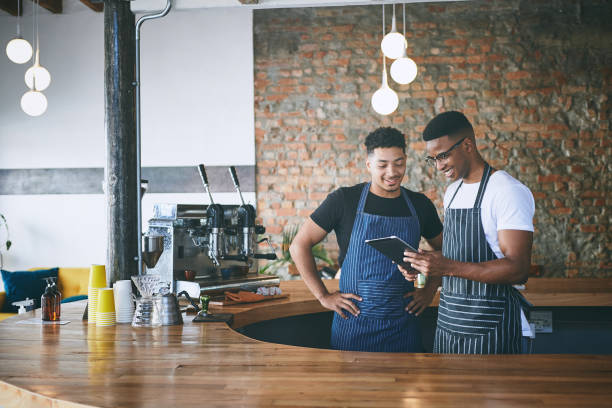 istock Shot of two young men using a digital tablet while working in a cafe 1318954404