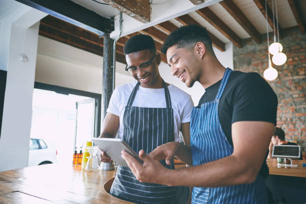 istock Shot of two young men using a digital tablet while working in a cafe 1318954417