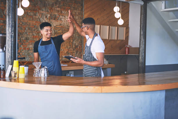 istock Shot of two confident young men using a digital tablet and giving each other a high five while working in a cafe 1318954558