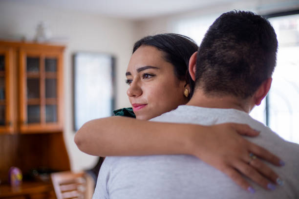 istock Man hugging woman at home 1318956297