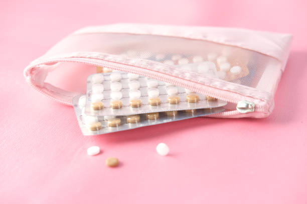 birth control pills on pink background, close up - birth control pill imagens e fotografias de stock
