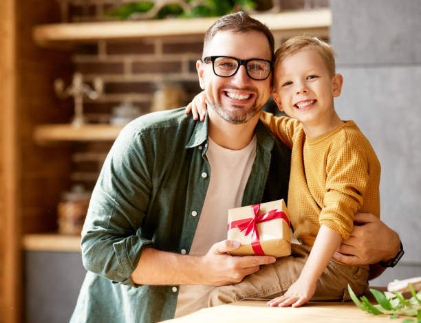 istock Excited boy son giving gift box for young loving father on holid 1318963415