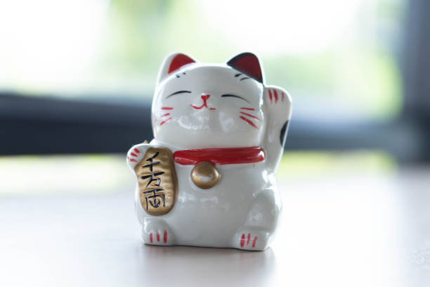 istock Maneki neko lucky cat show text on hand meaning rich on wood table background, select focus 1318963997