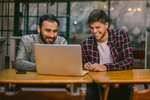 istock happy friends having fun with laptop 1318964351