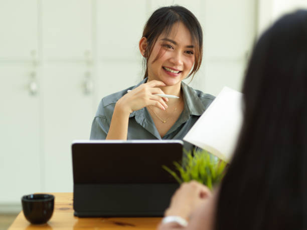 istock Female worker smiling and talking with her coworker while meeting on their project 1318965071