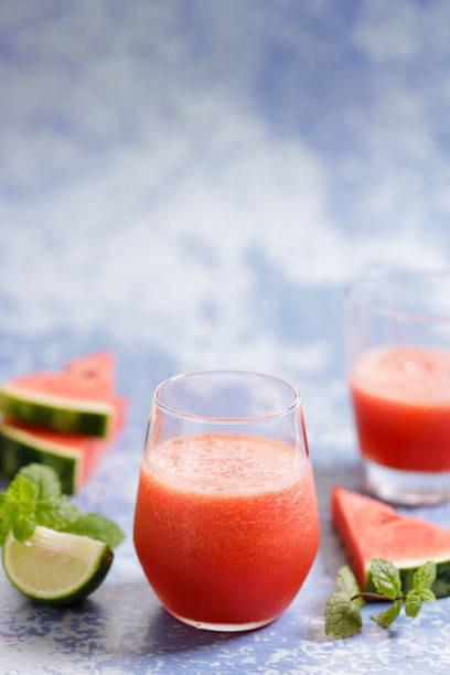 istock watermelon smoothie drinks on blue marble background. 1318969259