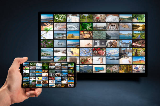 man holding mobile phone with many icons of video service on demand on background Oline TV VOD provider. Interface of video distribution service. Subscription Streaming video. Media TV on demand hombre sosteniendo el teléfono móvil con muchos iconos del servicio de vídeo bajo demanda en el proveedor de vod de tv en línea en segundo plano. servicio de distribución de vídeo de interfaz. servicio de suscripción. streaming de vídeo.