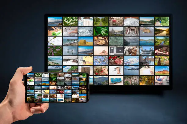 man holding mobile phone with many icons of video service on demand on background Oline TV VOD provider. Interface of video distribution service. Subscription Streaming video. Media TV on demand