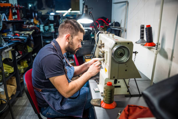 istock Young man in crafts repair shop using sawing machine 1318972684