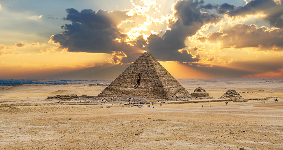 Pyramid of Menkaure. Ancient Pyramid Against Sky. Pyramid of Menkaure and Pyramids of Queens, Cairo. against the backdrop of a dramatic sky and sunset