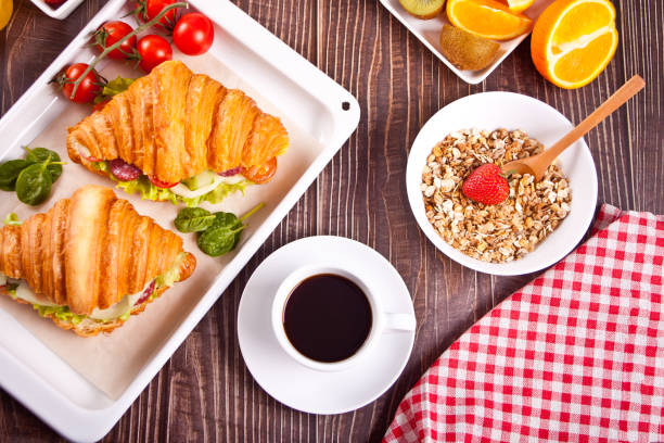 istock Croissant sandwiches with ham, cheese and greens on the baking rack. Breakfast concept. 1318973548