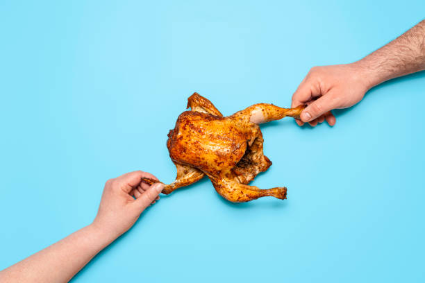 manger du poulet rôti sur fond bleu. les mains des gens saisissant le poulet. partager de la nourriture - roast chicken chicken roasted isolated photos et images de collection