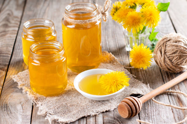 istock Dandelion honey in a jar and fresh flowers on a table 1318975756