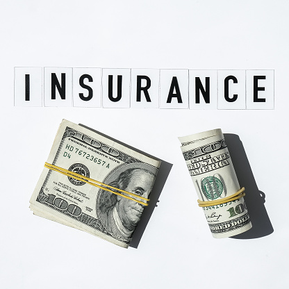 Text INSURANCE around US dollar banknotes. Health, life, home, car Insurance. Insurance business concept. Business budget of wealth and prosperity finance. Health care or medicare insurance and vaccination costs. Financial crisis. Covid-19 crimes