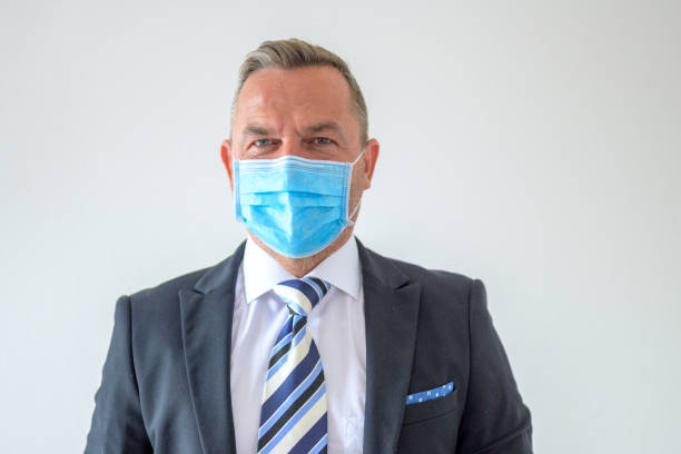 istock Unshaven businessman wearing a face mask and smart suit and tie 1318980708