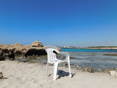 a white plastic beach chair sits in the water. Cyprus. Ayia Napa