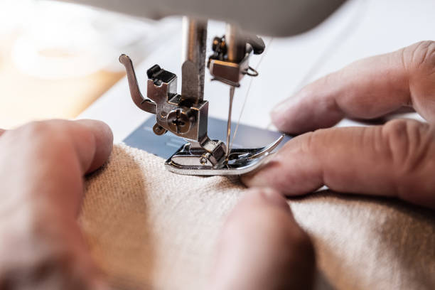 istock man is having a nasty accident with a sewing machine, sewing needle in his finger 1318987424