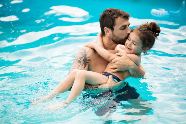 istock Father and son playing together in the swimming pool. 1318987582