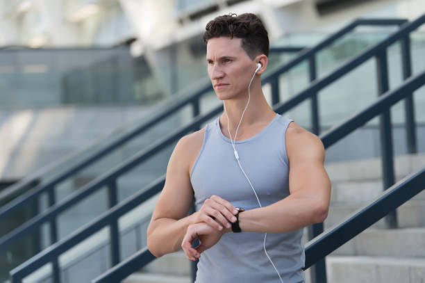 training and lifestyle concept. Runner with heart rate monitor sports smart watch. looking at watch. Training Hard outside of Gym. wrist-based heart rate monitor. Checking the running time. formación y concepto de estilo de vida. corredor con monitor de frecuencia cardíaca reloj inteligente deportivo. mirando el reloj. entrenando duro fuera del gimnasio. monitor de frecuencia cardíaca a base de muñeca. comprobación del tiempo de ejecuci�