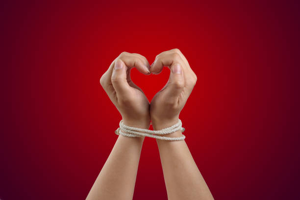 Hands in the shape of a heart tied with rope. Concept of the love of bdsm or codependency Hands in the shape of a heart tied with rope. Concept of codependency co dependent relationship stock pictures, royalty-free photos & images