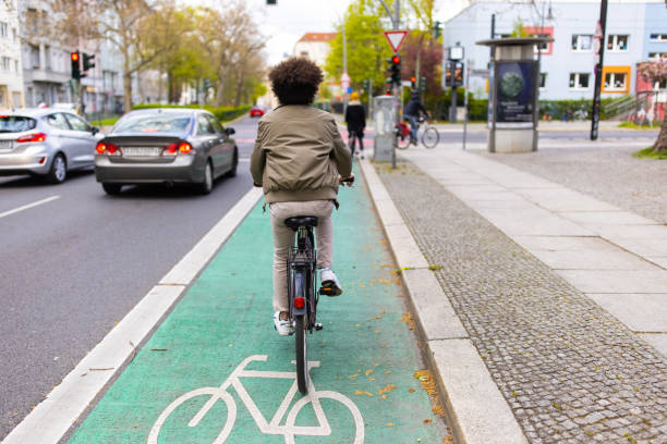 ciclista nel traffico cittadino con la pista ciclabile - asphalt road street dividing line foto e immagini stock