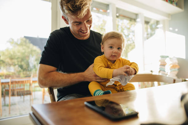 istock Smiling man with baby boy at home 1318992860