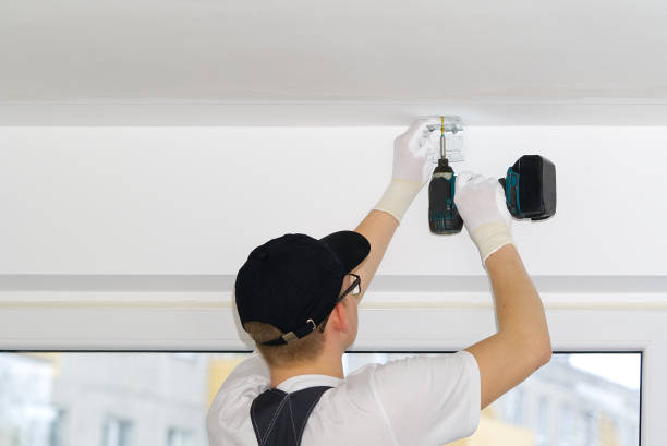 istock the master screws the metal corner to the concrete ceiling using a screwdriver, handyman 1318993923