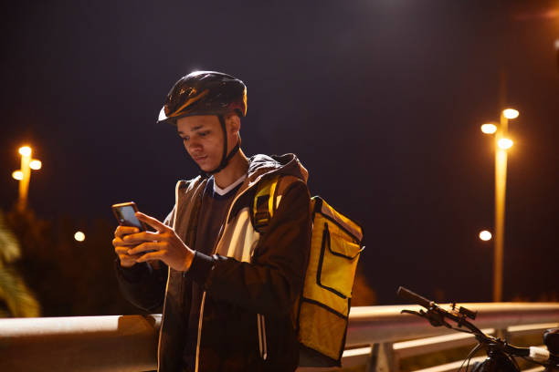 istock A young delivery person looking at his smartphone. 1318996610