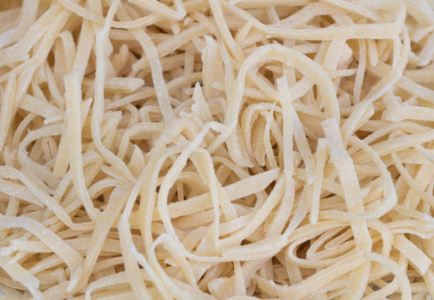 istock Fresh homemade uncooked pasta texture background. Recipe concept 1318999105