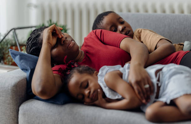 beautiful mother with little daughter and son sleeping on the sofa - african ethnicity brother ethnic little boys imagens e fotografias de stock