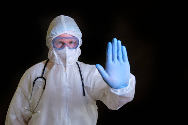istock A doctor in a covid protective suit makes a stop gesture with his hand 1319000778