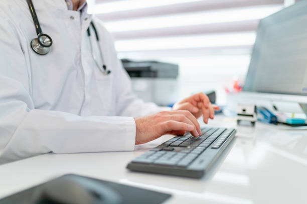 Typing on computer keyboard, doctor using modern technology at work Doctor's hands typing on computer keyboard at the office desk, using modern technology at work electronic medical record stock pictures, royalty-free photos & images